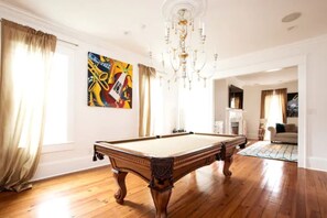 A spacious room with a pool table, a chandelier, and a painting on the wall. - Maison de l'Artiste | Curated NOLA Stay, Near the FQ (New Orleans)