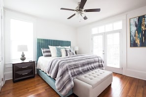 A bedroom with a bed, a nightstand, a ceiling fan, and a window. - Maison de l'Artiste | Curated NOLA Stay, Near the FQ (New Orleans)