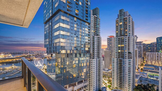 Un immeuble de grande hauteur doté d’une façade en verre, de nombreux balcons et offrant une vue sur le paysage urbain.