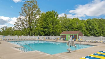 Una piscina al aire libre de temporada, sillones reclinables de piscina