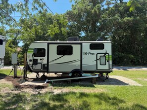 Ein stehender Wohnmobil mit Solarmodul, Generator und Wasserpumpe.
