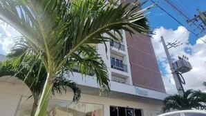 A multi-story building with a visible entrance and a parked car. - Flat -smart residence  (Teresina)
