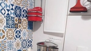 A kitchen with a black induction cooktop, stainless steel pots, and a red pot holder on the wall. - Flat -smart residence  (Teresina)