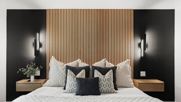 A modern bedroom with a large bed, multiple pillows, a bedside plant, and a wooden slat wall design. - Walk to Music Row and Vanderbilt, Only 1 Mile to Broadway (Nashville)
