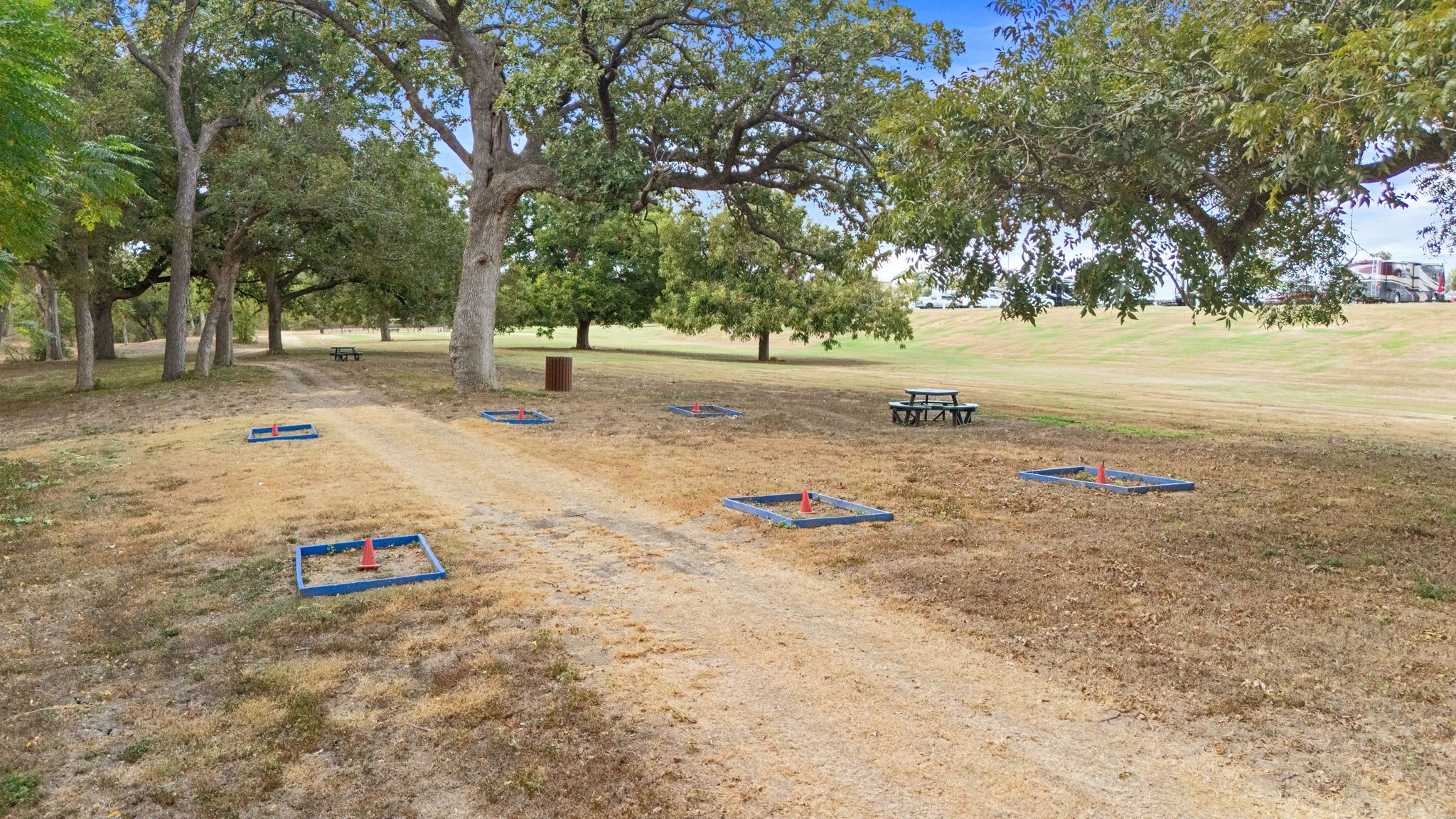 A park with picnic tables and blue play areas.
