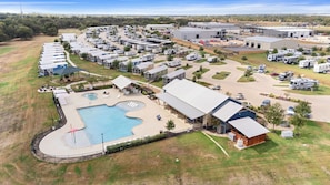 A campground with RVs, a swimming pool, and a large building.
