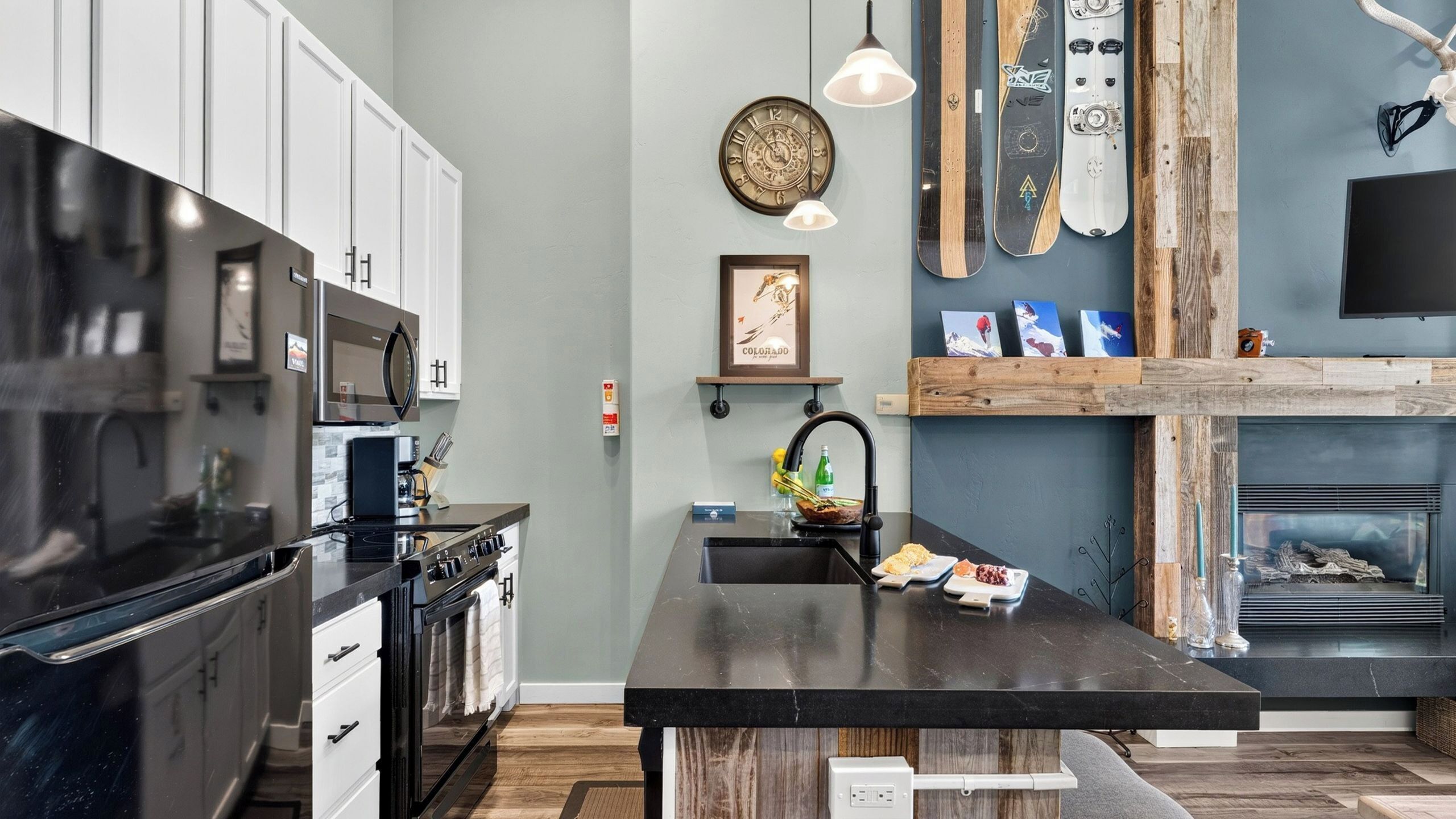 A modern kitchen with a central island, stainless steel appliances, and a wooden accent wall.