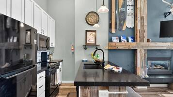 A modern kitchen with a central island, stainless steel appliances, and a wooden accent wall.