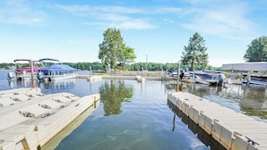 A marina with boats docked, a small dock, and trees in the background. - Total Escape LKA home w/ gameroom and water access (Mineral)