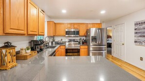 A kitchen with wooden cabinets, stainless steel appliances, and a granite countertop. - Total Escape LKA home w/ gameroom and water access (Mineral)
