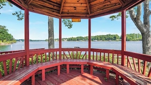 A wooden gazebo with a bench, overlooking a lake with trees and a clear sky. - Total Escape LKA home w/ gameroom and water access (Mineral)