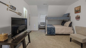 A bedroom with bunk beds, a television, a ceiling fan, and a small table. - Total Escape LKA home w/ gameroom and water access (Mineral)