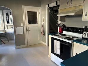 Eine Küche mit Herd, Backofen und einer roten Vase auf der Arbeitsfläche.