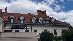 Un bâtiment avec un toit recouvert de tuiles rouges, de nombreuses fenêtres et une cheminée.