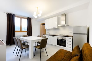 Eine moderne Küche mit weißen Schränken, einem eingebauten Backofen und einem Kühlschrank.
