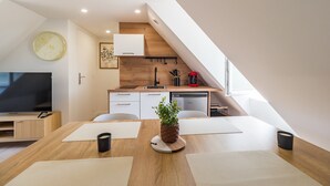A modern kitchen with a wooden countertop, a sink, and a red coffee maker.