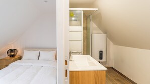A bedroom with a bed, bedside table, and lamp.