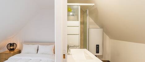 A bedroom with a bed, bedside table, and lamp.
