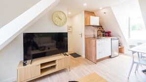 A modern kitchen with a built-in oven, a coffee machine, and a sink.