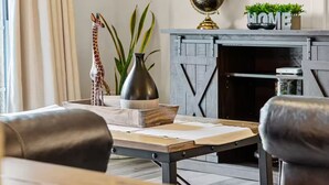 Ein Wohnzimmer mit Kamin, Globus und einem 'HOME' Schild.