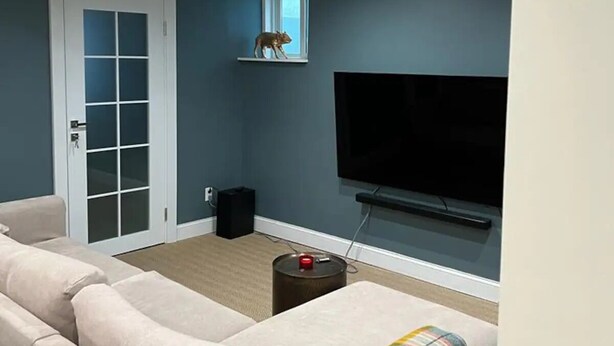 A living room with a sofa, a television, and a small speaker.