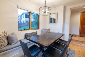 A dining area with a dark wooden table, black chairs, and a light fixture above. - PARQ at Portico Private Hot Tub Walk to Main Street Free Shuttle to Ski Resorts (Park City)