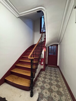 A staircase with wooden steps and a red handrail, leading to a door with a window. - Tiny house cozy design at the gates of Paris - Le Pré-Saint-Gervais (Le Pré-Saint-Gervais)