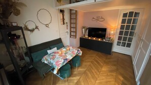 Een gezellige woonkamer met een bank, een tafel met kaarsen, en een televisie.