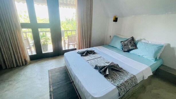 Un dormitorio con cama, cortinas, ventana y puerta.