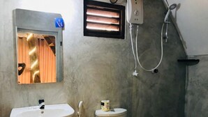 Un baño con lavamanos, inodoro, ducha y ventana con cortinas.