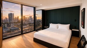 A bedroom with a large bed, a nightstand, a view of a cityscape through floor-to-ceiling windows, and a dark green accent wall. - E2304 - Stylish New Studio in Downtown Miami (Miami)
