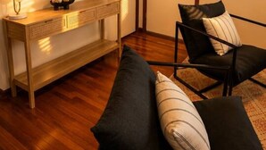 A living room with a sofa, a console table, and wall-mounted artwork.
