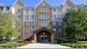 A multi-story hotel with a stone facade, large windows, and a central entrance with a decorative arch.