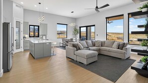 Un interior moderno con cocina, comedor y sala de estar, con ventanas amplias y vistas al desierto.