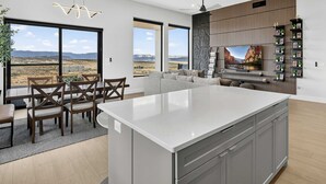 Una cocina moderna con una isla grande, electrodomésticos integrados y un comedor con vistas al desierto.