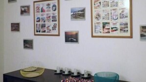 A room with a dark wooden desk, a teal bowl, and a framed collage of pictures on the wall. - Funchal Petrolhead Apartment (Funchal)