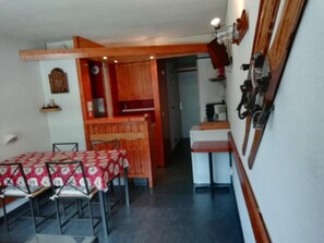 A compact kitchen with a dining area, wooden cabinets, and a small table. - 100m from ski slopes, 2nd floor, balcony, tv, ski locker, 28m², Les Arcs (Les Arcs)