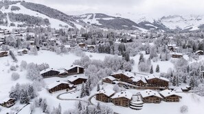 Ein schneebedecktes Gebirgskurort mit Holzhäusern und einer Skipiste.