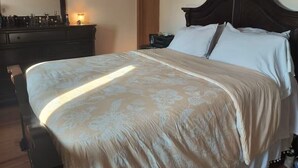 A bedroom with a bed, dresser, and mirror.