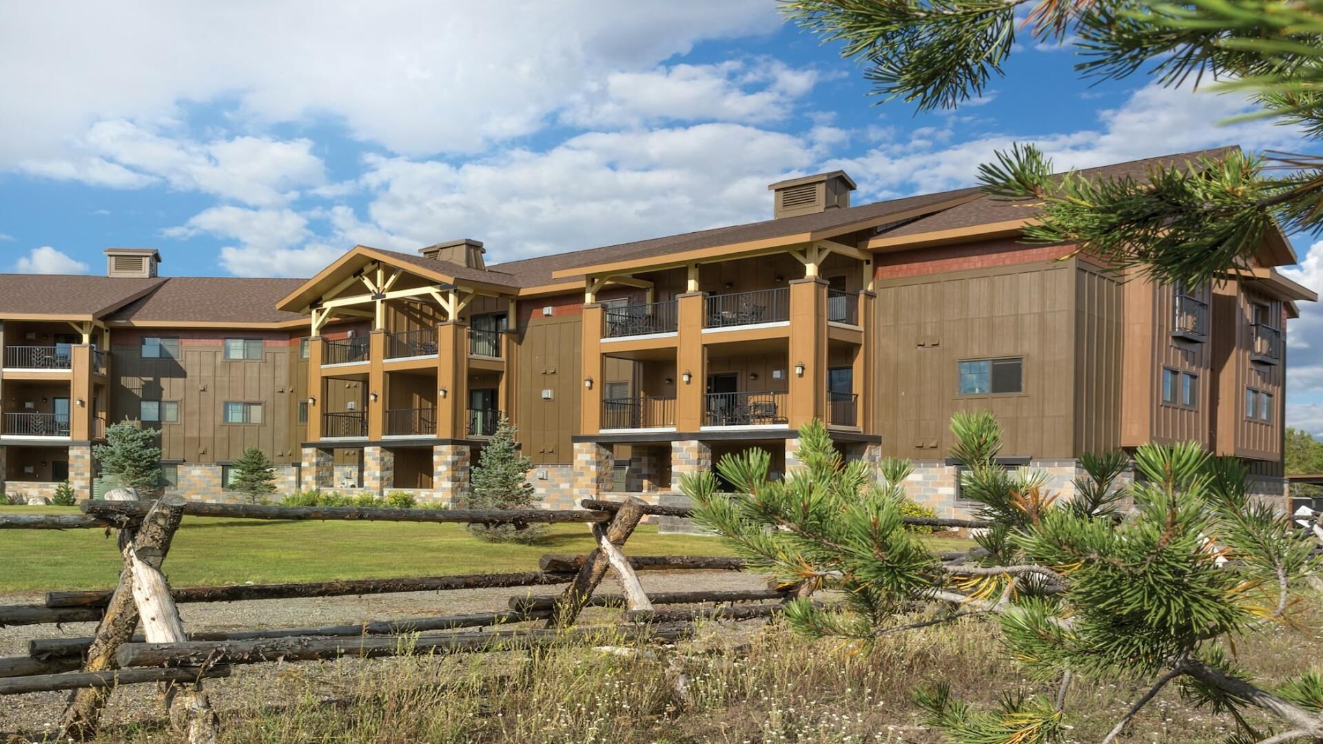 A multi-story hotel with a central courtyard, balconies, and a mix of brick and wood exterior.