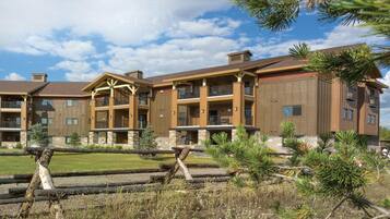 A multi-story hotel with a central courtyard, balconies, and a mix of brick and wood exterior.