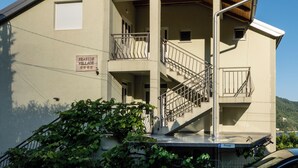 A two-story building with a balcony, a staircase, and a sign indicating 'SEASIDE VILLAGE.' - Seaside Village apartments (Herceg Novi)