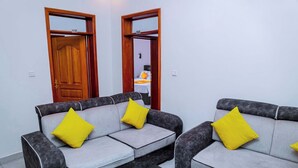 A room with two grey sofas with yellow cushions, a black table, and wooden doors with numbers 510 and 509. - Martin aviator hotel (Kigali)