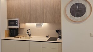 A modern kitchen with a built-in microwave, coffee machine, and a sink with a faucet. - Ponto Norte | Room 2 | Town Centre | Melgaço | The Northernmost Town in Portugal (Melgaço)