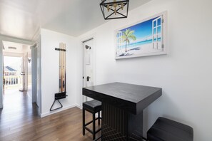 A room with a pool table, a painting of a beach, and a door leading to a balcony. - Atlantic Inspiration @ Kitty Hawk Ocean Front (Kitty Hawk)