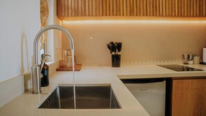 Une cuisine moderne avec un évier en acier inoxydable, un robinet et un meuble en bois au-dessus.