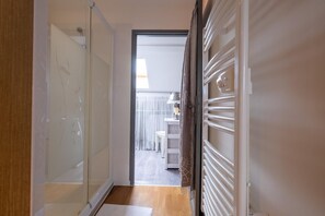 A hallway with a sliding door leading to a room with a radiator and a small table with a lamp. - Oya Vacation Rental - CHAUDEYRAC - Vacation Rental (CHAUDEYRAC)