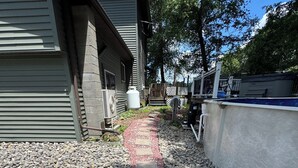Un chemin menant à un bâtiment doté d’un réservoir d’eau et de mobilier d’extérieur.