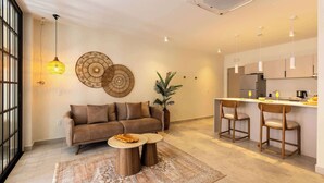 Un salon moderne avec un canapé, une table basse et des tabourets de bar.