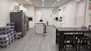 Una cucina moderna con frigorifero, forno e microonde. C'è un'area pranzo con tavolo e sedie.